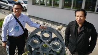 Zwei Männer neben Getriebe. Zwei Männer neben Getriebe.
