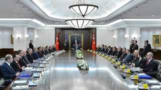 Kabinettsmitglieder sitzen an einem ovalen Tisch.