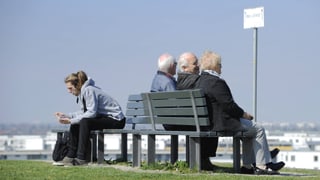 Symbolbild: Rentner sitzen auf einer Bank, auf der anderen Seite ein rund 30-jähriger Mann.