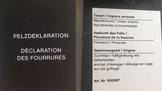 Etikett einer Wollmütze mit Pelzbommel. Etikett einer Wollmütze mit Pelzbommel.