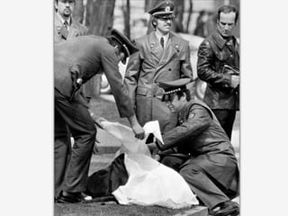 Polizisten decken am 7. April 1977 die Leiche von Generalbundesanwalt Siegfried Buback nach dessen Ermordung durch RAF-Terroristen ab. 