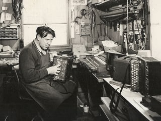 Schwarz-Weiss-Fotografie mit einem Instrumentenbauer in seiner Werkstatt.