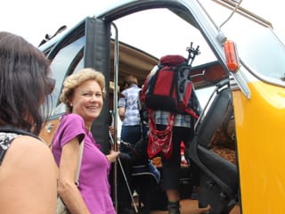 Ein paar Wanderer steigen ins Oldtimer-Postauto ein.