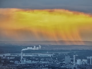 Schornsteine im Vordergrund, Regenschauer im Hintergrund.
