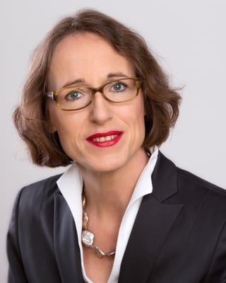 Jutta von Falkenhausen mit Brille lächelt in die Kamera.