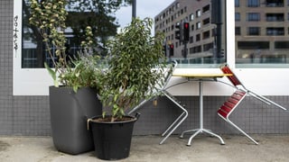Vor einem geschlossenen Geschäft sind Stühle an einen Tisch gelehnt. Vor einem geschlossenen Geschäft sind Stühle an einen Tisch gelehnt.