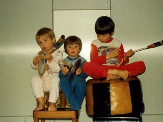 Drei Kinder im Pajama mit Tennisschlägern als Ersatzinstrumente. 