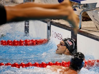 Super Timing: Ein unbekannter Schwimmer gewinnt die noch junge olympische Disziplin Fuss-Photo-Bombing.