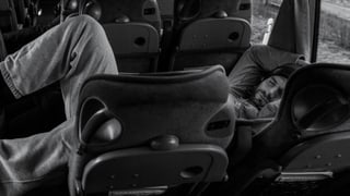 Ein Mann liegt in einem Mannschafts-Bus und schläft. Ein Mann liegt in einem Mannschafts-Bus und schläft.