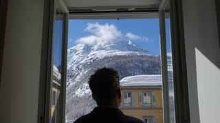 Mann schaut aus Fenster, Bergpanorama im Hintergrund Mann schaut aus Fenster, Bergpanorama im Hintergrund