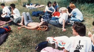 Jugendliche sitzen auf eine Wiese, ein Mädchen trägt ein Live Aid Shirt. Jugendliche sitzen auf eine Wiese, ein Mädchen trägt ein Live Aid Shirt.