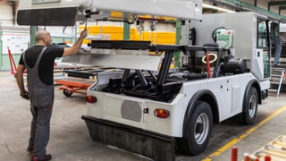 In einer Fabrikhalle wird eine Strassenputzmaschine zusammengebaut. 