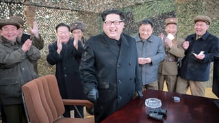 Kim Jon Un in einem Tarnzelt lachend.