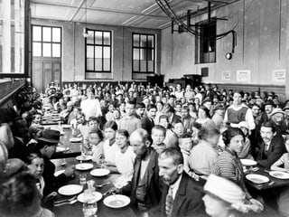 Ein Esslokal in der Dreirosen-Turnhalle. Es ist gefüllt mit Menschen, die essen wollen.