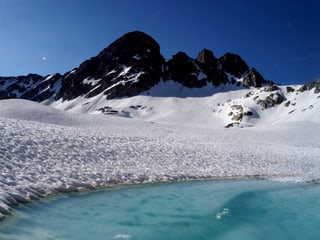 Ein Gletschersee erwacht mitten im Schnee.