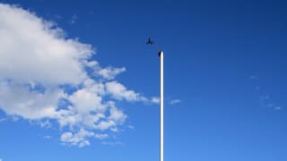 Aufnahme eines Windmastes im Tessin unter blauem Himmel.