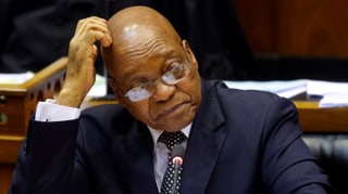 Porträtaufnahme von Zuma: Er sitzt im Parlament mit aufgestütztem Arm und kratzt sich am Kopf.