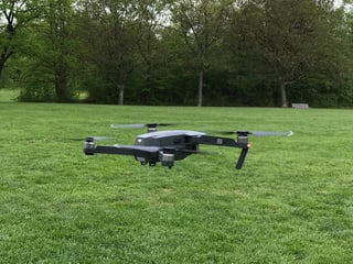 Drohne fliegt über einen Rasen