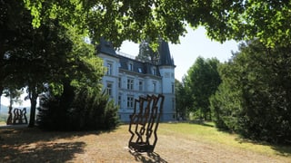 Blick auf eine grosse Villa, im Vordergrund Parkanlage mit Kunstwerk Blick auf eine grosse Villa, im Vordergrund Parkanlage mit Kunstwerk
