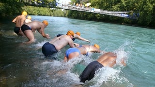 Schwimmer springen in die Aare in Bern. 