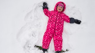 Ein Kind tollt im Schnee.