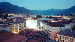 Ein Foto von Locarno mit dem Filmfestival auf dem Piazza Grande und den Alpen im Hintergrund.