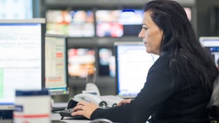 Eine Frau sitzt vor einem Computerbildschirm.