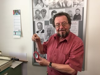 Der Erfinder präsentiert in seinem Atelier eine Lupe mit einer Kette.
