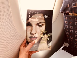Das Buch von Golnaz Hashemzadeh Bonde: «Was bleibt von uns» vor einem Flugzeugfenster