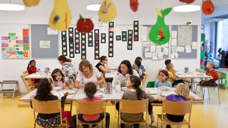 Kinder sitzen in einem Hort zum gemeinsamen Essen am Tisch Kinder sitzen in einem Hort zum gemeinsamen Essen am Tisch