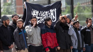 Salafisten demonstrieren, zu sehen auch eine schwarze Fahne mit weisser, arabischer Schrift.