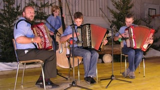 Drei Akkordeonspieler und eine Kontrabassistin auf einer Konzertbühne.