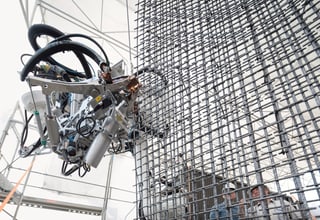 Roboter arbeitet an einer Stahlbetonwand.