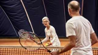 Rentner spielen Tennis. 