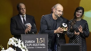 Ein Mann hält den soeben erhaltenen Preis-Pokal vor das Publikum. Ein Mann hält den soeben erhaltenen Preis-Pokal vor das Publikum.