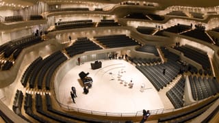 Einblick in den riesigen Konzertsaal mit terrassenartig angelegten Tribünen. Einblick in den riesigen Konzertsaal mit terrassenartig angelegten Tribünen.
