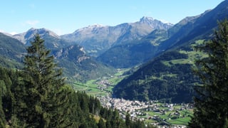 Eine idyllische Landschaft mit Dorf von oben: er ist eingesäumt durch Berge und Wälder. Eine idyllische Landschaft mit Dorf von oben: er ist eingesäumt durch Berge und Wälder.