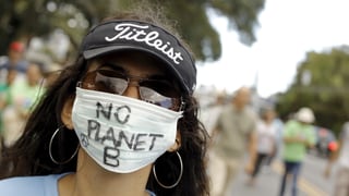 Eine Demonstrantin trägt einen Mundschutz mit der Aufschrift «No Planet B»