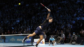 Roger Federer spielt einen hohen Ball mit einem spektakulären Rückhand-Volley ins Feld zurück.