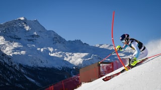 Skifahrerin zwischen Slalomstangen in St.Moritz, im Hintergrund ein Berg.