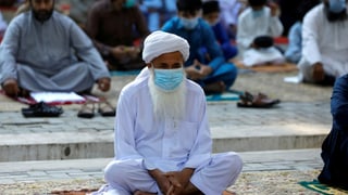 Ein muslimischer Gläubiger mit einer Schutzmaske in einer Moschee.