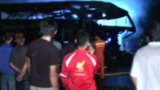 Schaulustige betrachten den abgebrannten Doppeldeckerbus. Schaulustige betrachten den abgebrannten Doppeldeckerbus.