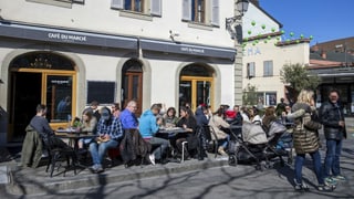 Gäste sitzen auf einer Terrasse eines Cafes.