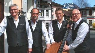 Vier Musikanten mit weissen Hemden und dunklen Westen auf einem Gruppenbild.