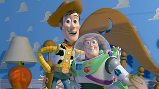 Zwei Figuren aus dem Film «Toy Story», ein Cowboy und ein Astronaut, posieren auf einem Kinderbett.