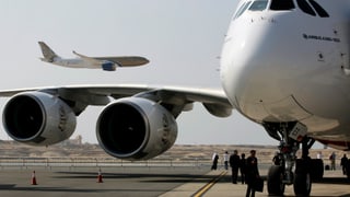 Vorne am Boden ein Airbus von Emirates, hinten eine Maschine der Gulf-Airlines im Landeanflug.