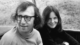 Foto schwarzweiss: rechts eine Fraue mit langen Haaren und verschränkten Armen, lächelt in die Kamera. Links ein Mann mit Hornbrille und mittellangem Haar schaut aus dem Bild und lächelt leicht. Foto schwarzweiss: rechts eine Fraue mit langen Haaren und verschränkten Armen, lächelt in die Kamera. Links ein Mann mit Hornbrille und mittellangem Haar schaut aus dem Bild und lächelt leicht.