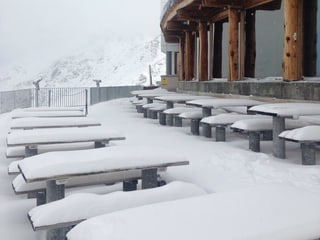 Eine Schneedecke auf den Bänke und Tischen eines Restaurants