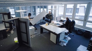 Zwei Mitarbeiter räumen ein Büro.