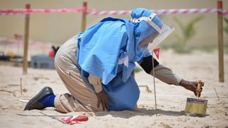 Eine Person beim Entschärfen einer Landmine.